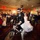 Bride and groom enters their wedding reception with a tandem bike at Primavera Regency, NJ