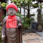 A stone statue wearing a knit cap at the Buddhist temple in Takarazuka, Japan, photographed by Kyo Morishima