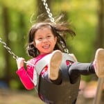 Child on swing in Roosevelt Park, Edison, by Metuchen family photographer Kyo Morishima