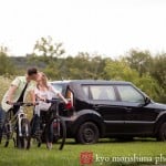 Couple on bikes kissing in front of hatchback: Kittatinny State Park outdoor engagement portrait pictures by central NJ wedding photographer Kyo Morishima