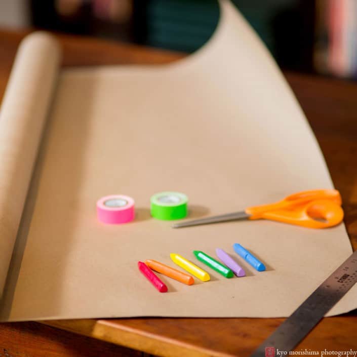 Crayons and kraft paper about to be used as table decor at a casual family dinner party, photographed by Kyo Morishima