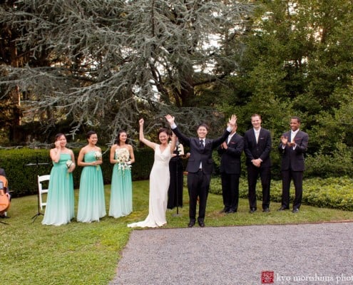 Bride and groom celebrate after ceremony ends, as bridesmaids and groomsmen look on, photographed by Kyo Morishima