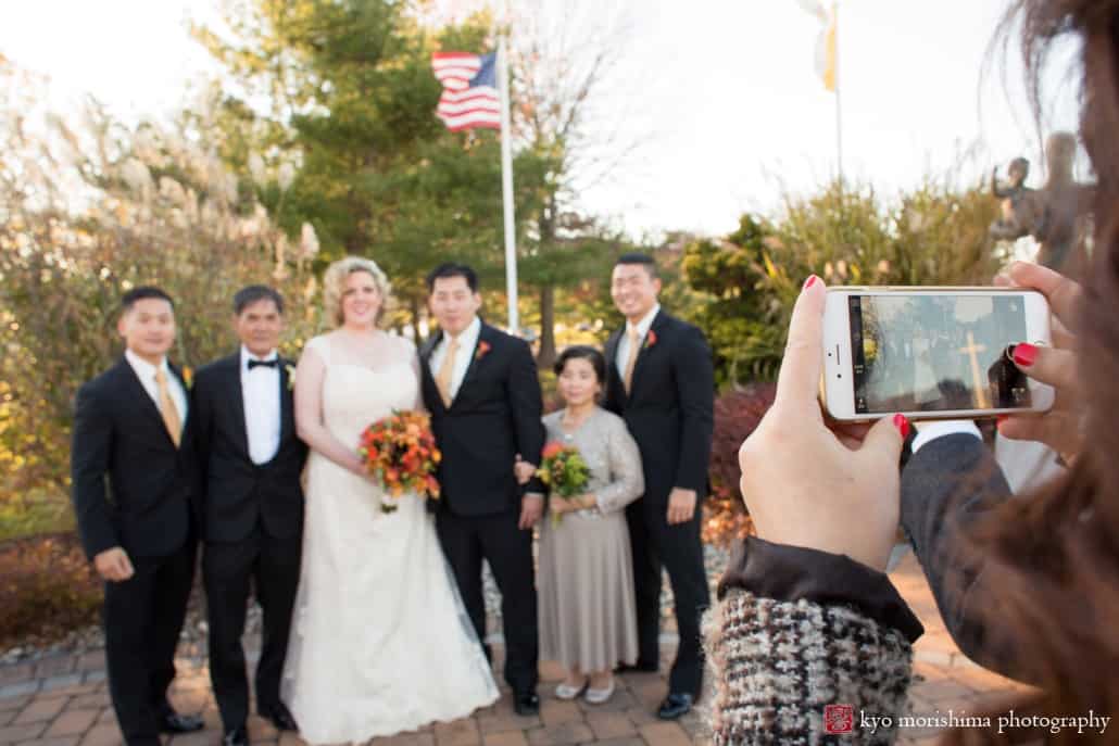 Wedding guests snaps an iphone photo of the bride and groom with family, photographed by Plainsboro wedding photographer Kyo Morishima