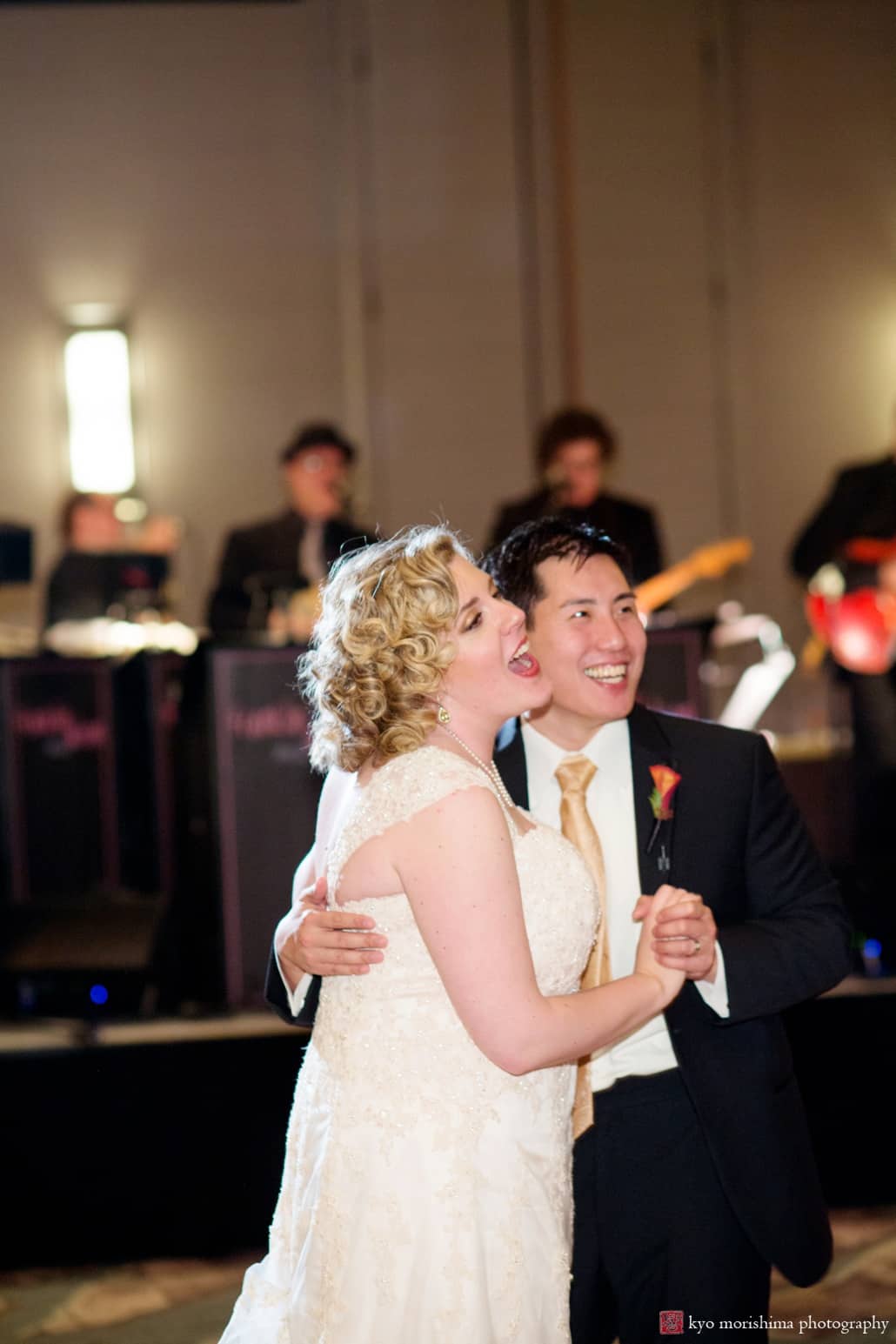 Bride and groom laugh during dance at Westin Forrestal Village wedding, with Franklin and Alison orchestra playing behind them, photographed by Kyo Morishima