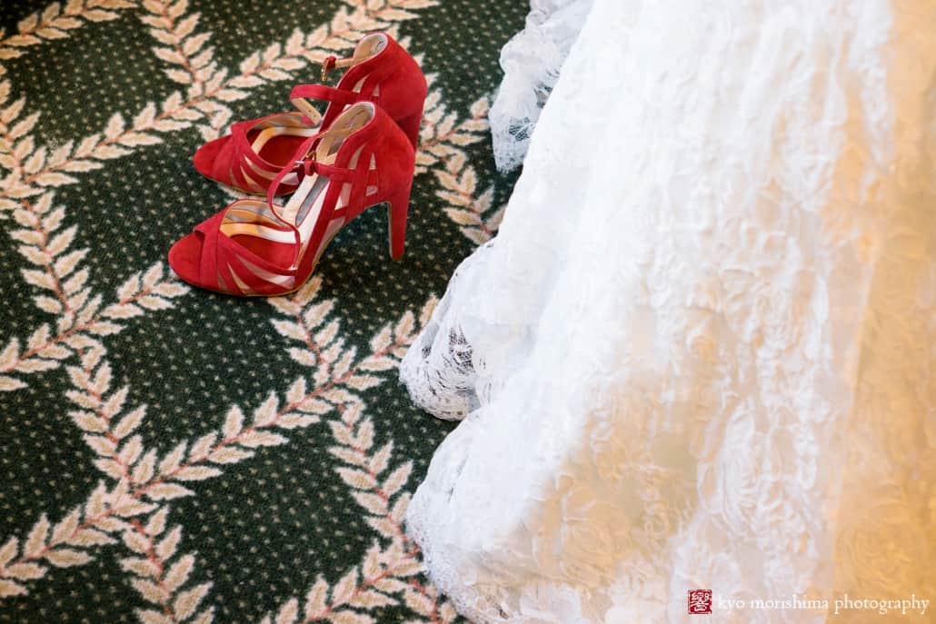 Red wedding shoes on green carpet with glimpse of wedding dress at Olde Mill Inn, photographed by NJ documentary wedding photographer Kyo Morishima