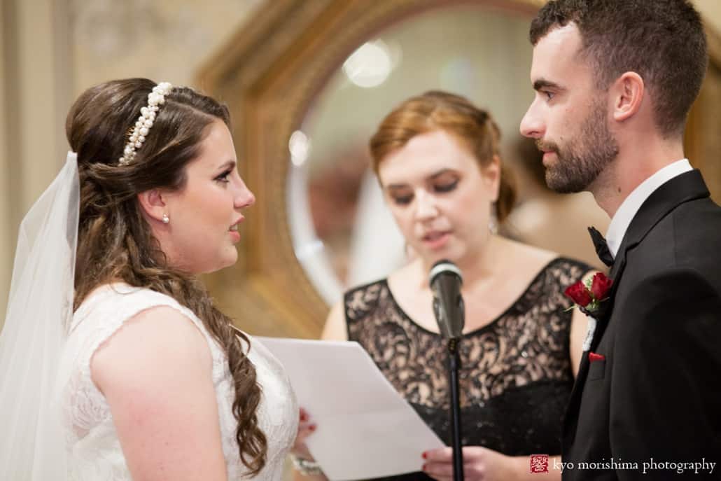 Bride and groom listen to officiant during Olde Mill Inn wedding, photographed by Kyo Morishima
