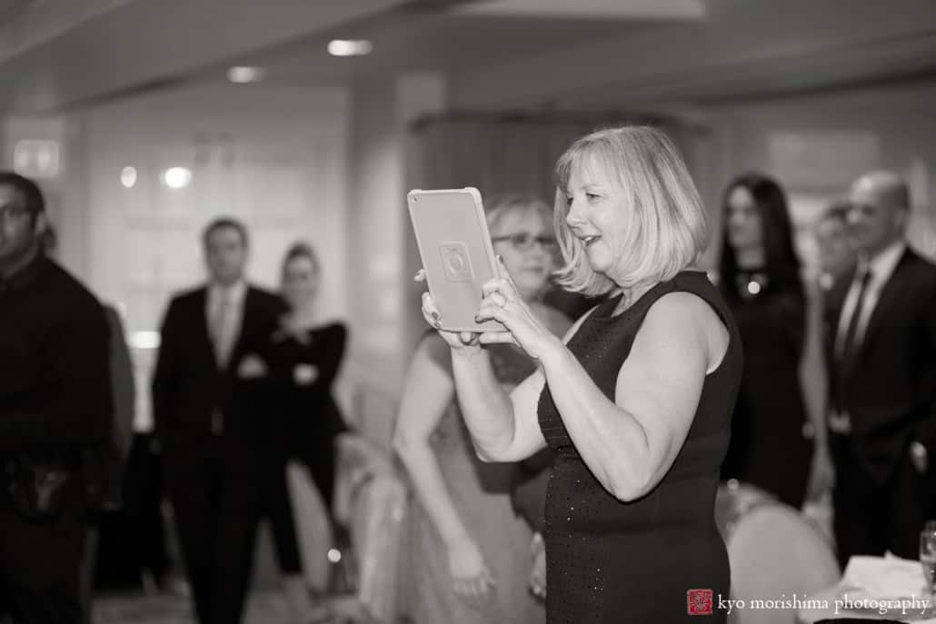 Guest uses iPad to take a picture at Olde Mill Inn wedding reception, photographed by Kyo Morishima