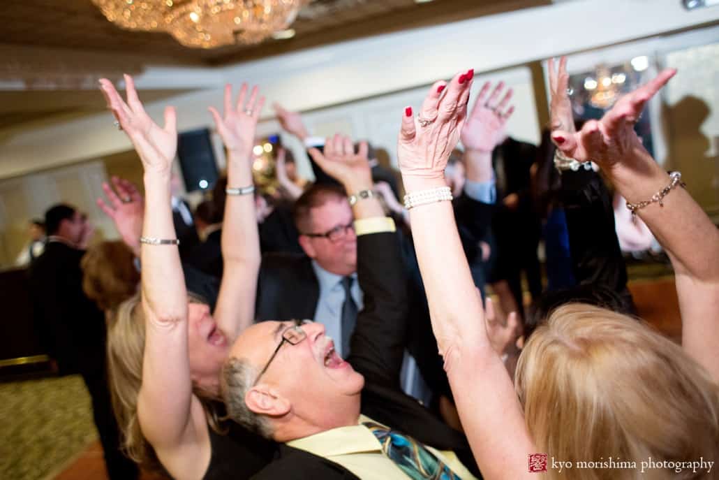 Guests raise their arms on the dance floor at Olde Mill Inn wedding photographed by Kyo Morishima