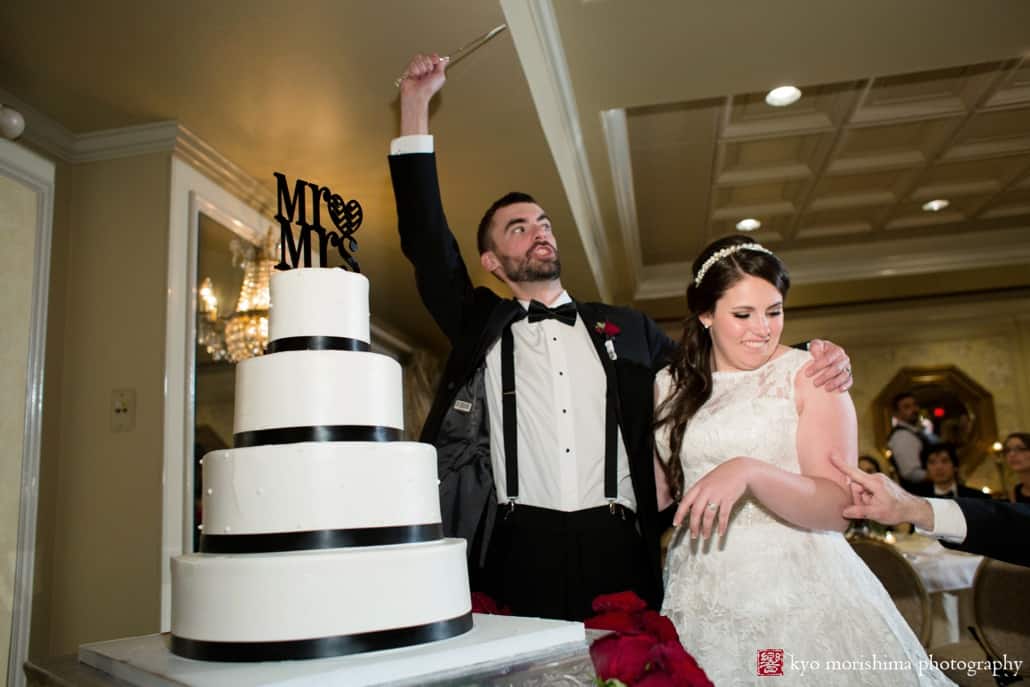 Groom raises knife for cake cutting at Olde Mill Inn wedding photographed by Kyo Morishima