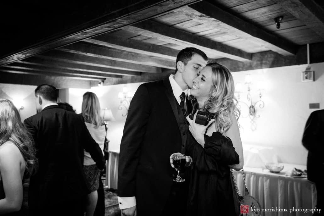 A kiss during cocktail hour in Lobby 2 at a Nassau Inn March wedding, photographed by NJ photojournalistic wedding photographer Kyo Morishima
