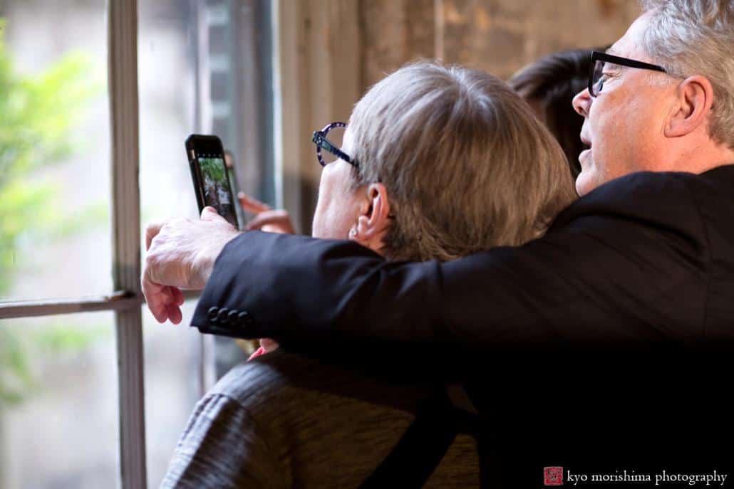 Father and mother of the bride take an iphone photo of wedding portrait session, photographed by Kyo Morishima