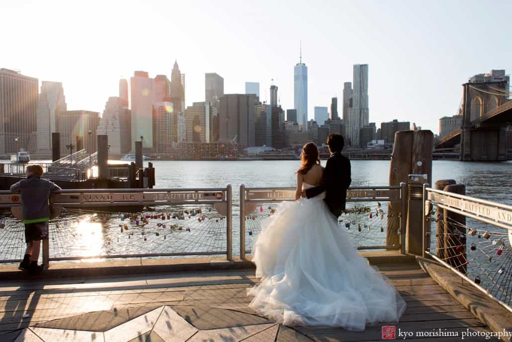 Japanese couple on their NYC wedding photo tour gaze at Manhattan skyline across the East River, photographed by Kyo Morishima