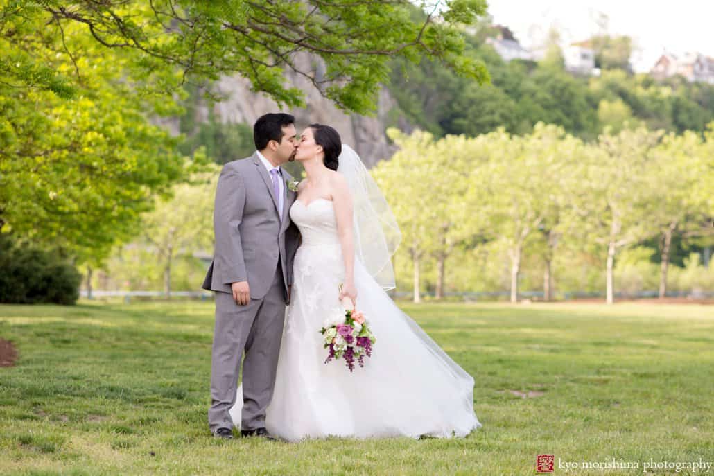 Bride and groom kiss during wedding portrait session at Weehawken Waterfront Park, photographed by Kyo Morishima