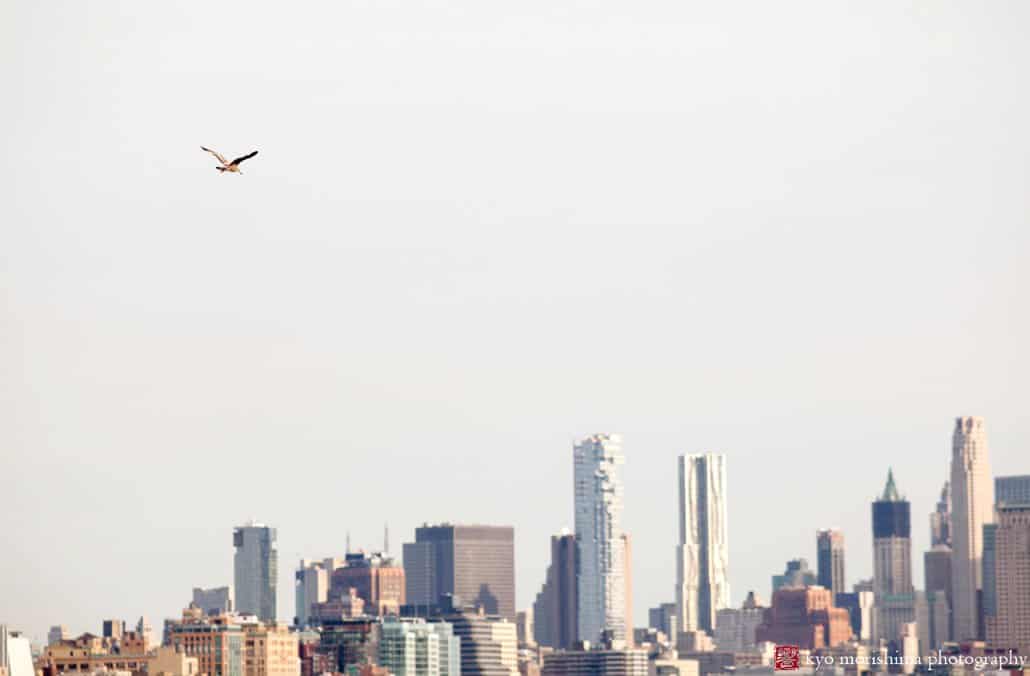 Seagull flies toward Manhattan during Chart House wedding ceremony, photographed by Kyo Morishima