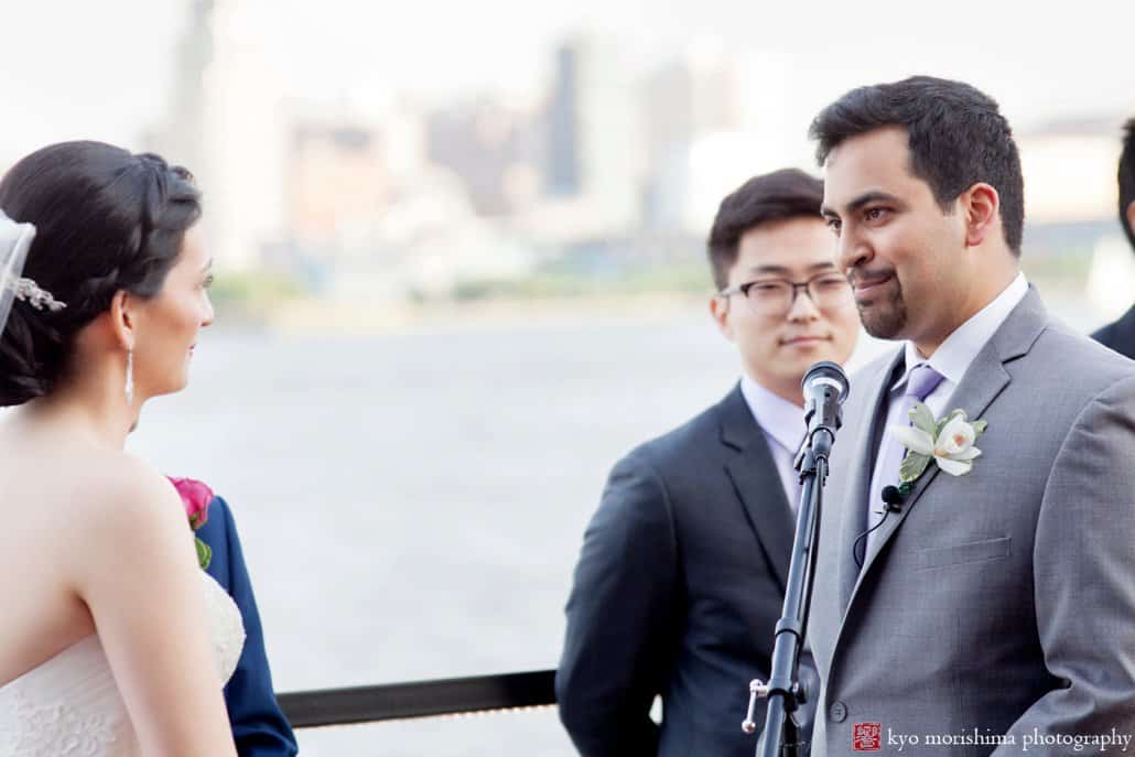 Groom looks at bride during Chart House wedding ceremony on the terrace, photographed by Kyo Morishima
