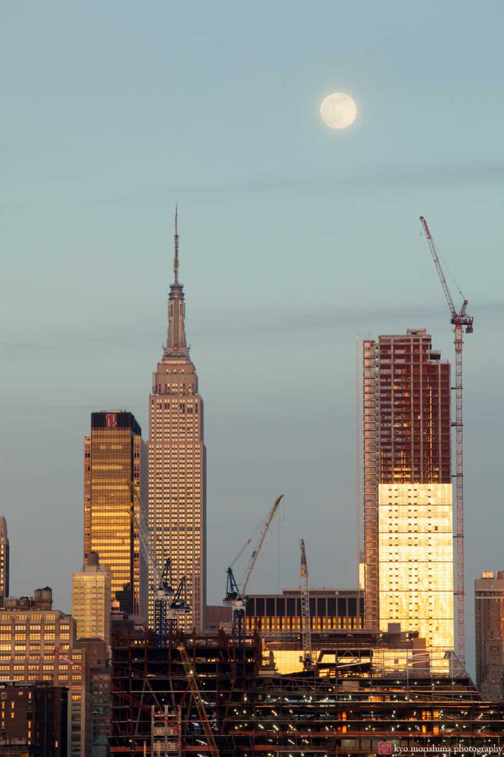 A view of Manhattan construction from Chart House tinged gold by evening sun, photographed by Kyo Morishima