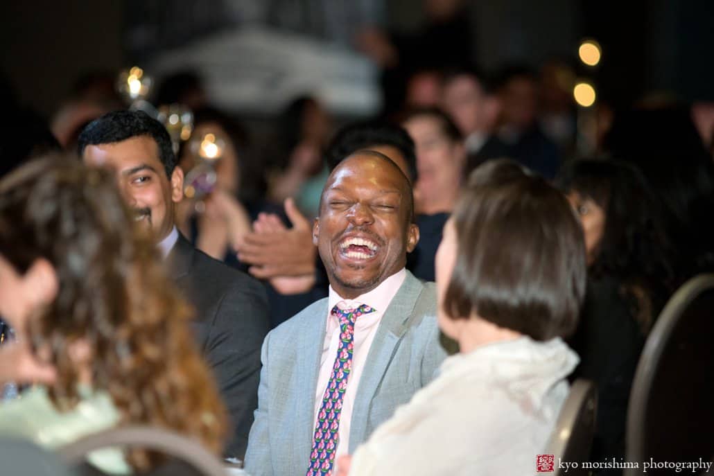 Guest laughs during toasts at Chart House wedding reception, photographed by Kyo Morishima