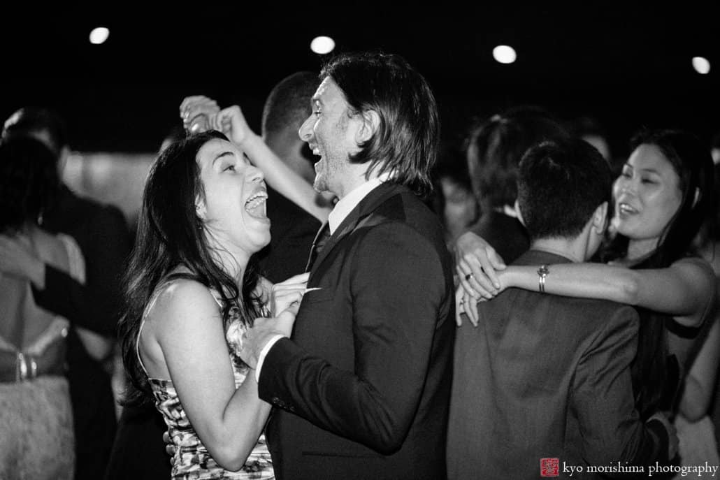 Guests laugh during dancing at Chart House wedding reception, photographed by Kyo Morishima