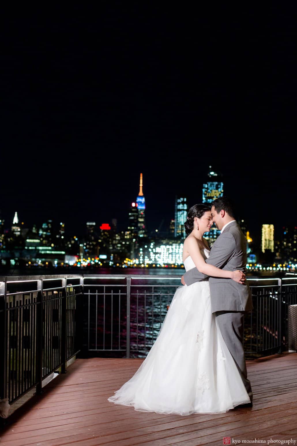 Bride and groom outdoor evening portrait on Chart House terrace with Manhattan in the background, photographed by Weehawken wedding photographer Kyo Morishima