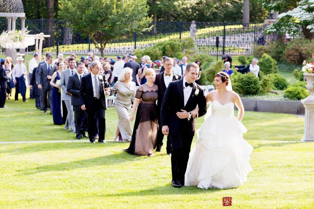 Bride and groom lead a line of guests departing Princeton garden wedding ceremony at Jasna Polana, photographed by Kyo Morishima