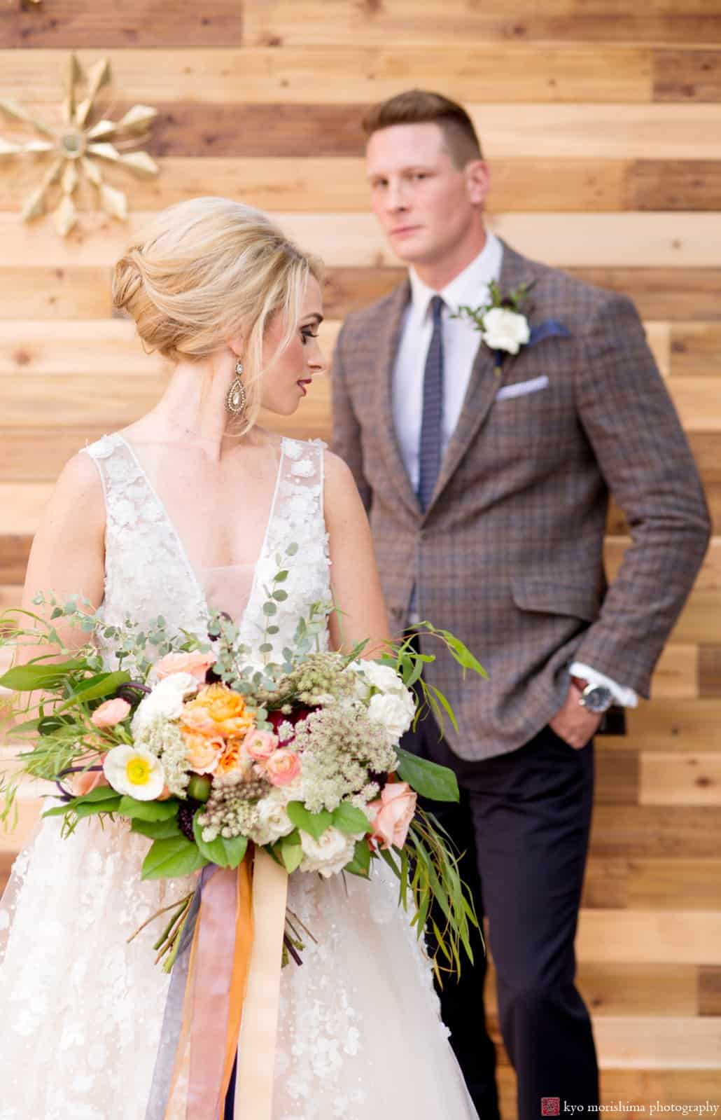 Madmen wedding photo shoot at the Nassau Inn, Princeton, styled by Kristin Rockhill of Details of I Do. 1960s-style updo hair by Letitia Kakas, smoky eyes makeup by Gena Verde Longo. Pale apricot, pink, white, and somky green wedding bouwuet with multi-colored ribbon. photographed by Kyo Morishima