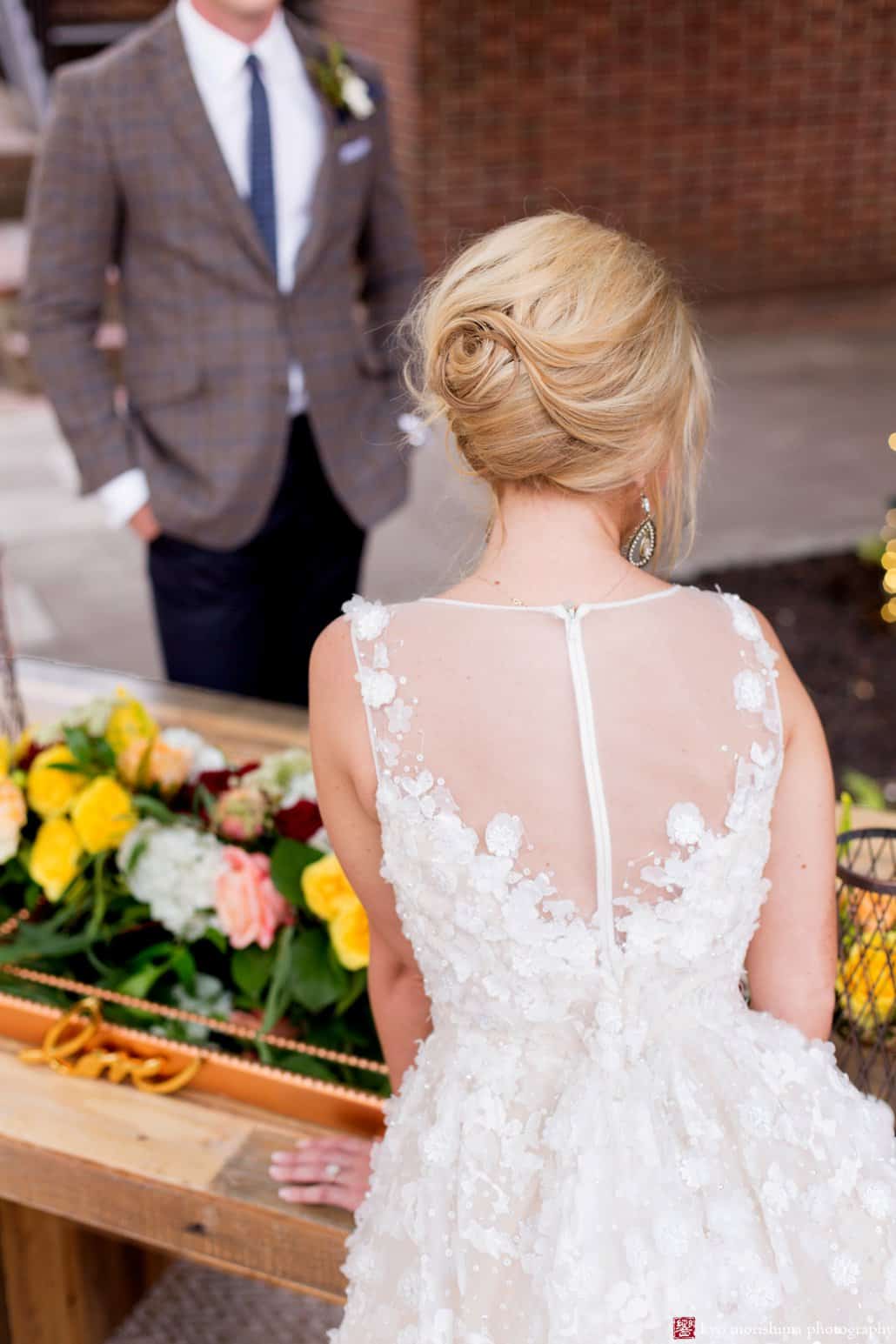 Detail of the back of BHLDN Ariane wedding gown with bride's 1960s updo wedding hair styled by Letitia Kakas, on the Nassau Inn back patio in Princeton, photographed by Kyo Morishima