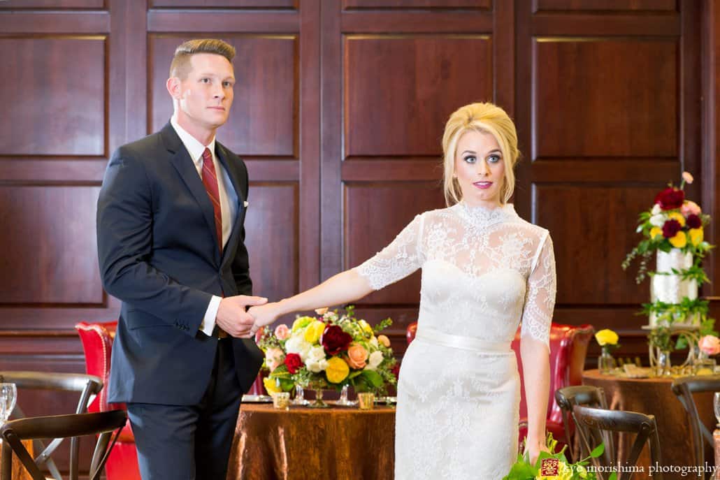 Bride wearing Bridgette wedding gown from BHLDN stands with groom in Nassau Inn ballroom during 