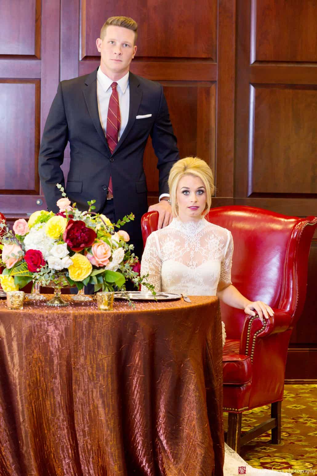 Maroon, gold and white flower centerpiece in the Nassau Inn ballroom, with bride wearing Bridgette wedding gown from BHLDN, during Nassau Inn 