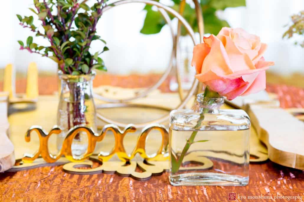 Detail of gold table decor with single rose and foliage styled by Kristin Rockhill of Details of I Do, photographed by Kyo Morishima