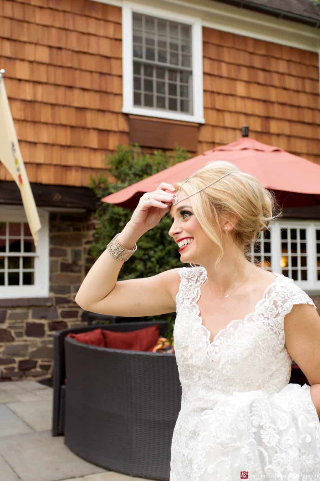 Bride smiles outside Nasssau Inn in Princeton. Bride wears BHLDN wedding gown, 1960s-style updo hair by Letitia Kakas, smoky eyes makeup by Gena Verde Longo. photographed by Kyo Morishima