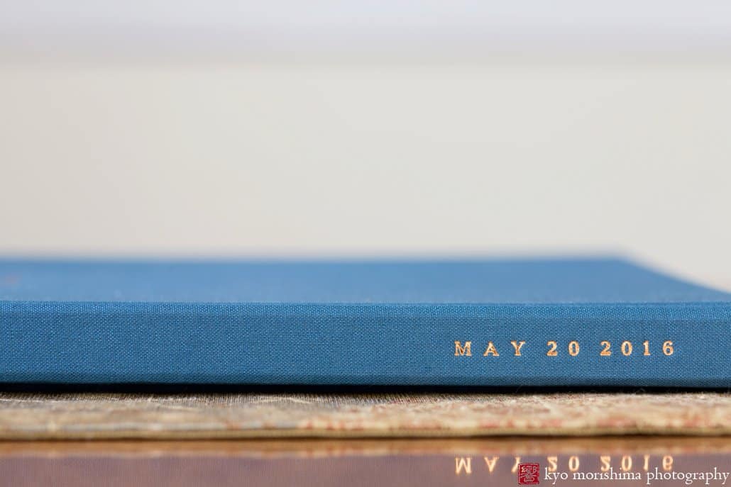 Closeup of spine of Artifact Uprising wedding guest book in Pacific Blue with copper foil stamping, as photographed by Kyo Morishima