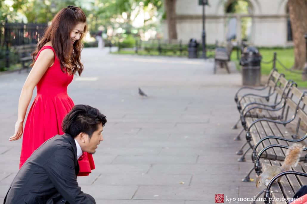 A couple make friends with a squirrel near City Hall in downtown NYC, photographed by Japanese engagement photographer Kyo Morishima