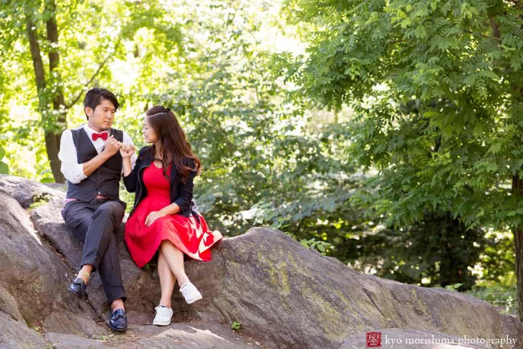 Sitting on a rock in Central Park: Japanese engagement photo in NYC photographed by Kyo Morishima