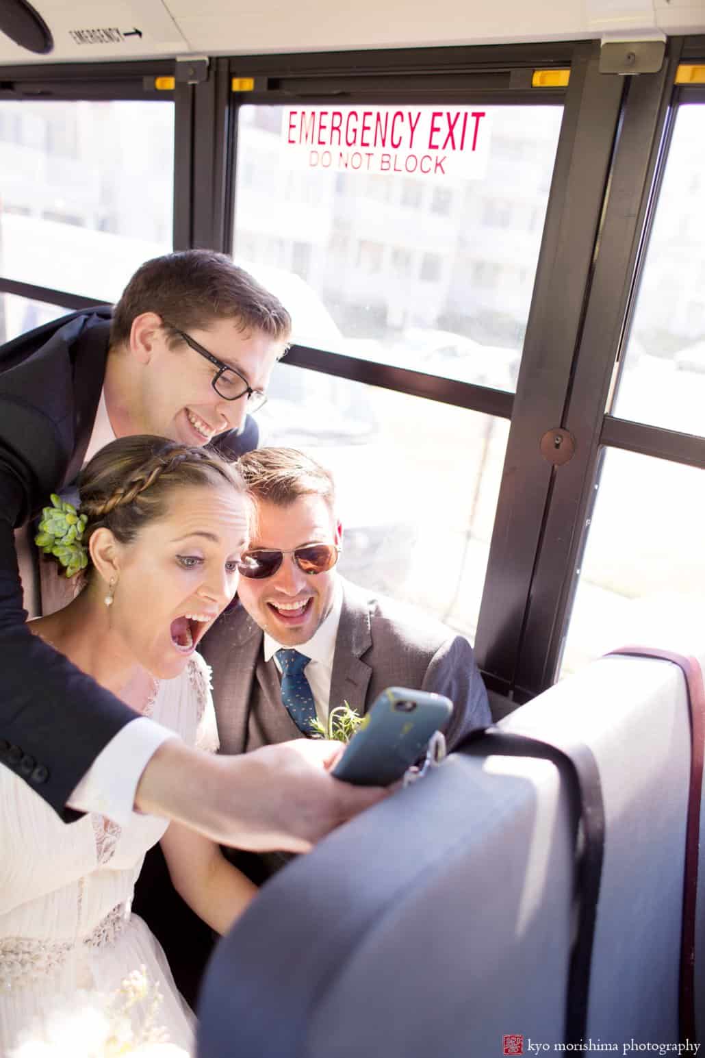 Groomsman takes a selfie with bride and groom inside school bus, photographed by Asbury Park wedding photographer Kyo Morishima