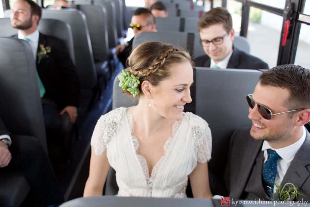 Bride and groom smile at each other during school bus ride to portraits on the Asbury Park boardwalk, photographed by Kyo Morishima