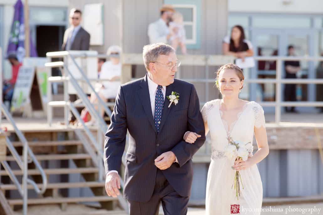 Father looks at bride as he escorts her to Asbury Park beach wedding ceremony, photographed by Kyo Morishima