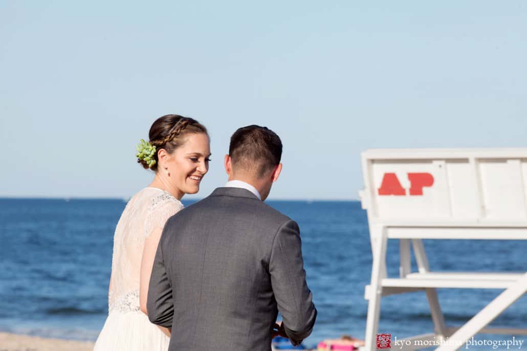 Bride and groom walk away from ceremony to throw a message into the ocean during Asbury Park wedding, photographed by Kyo Morishima