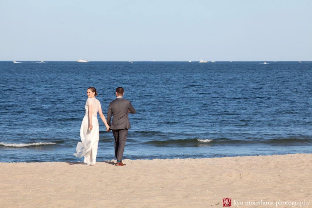 Bride and groom walk toward ocean during Asbury Park wedding, photographed by Kyo Morishima