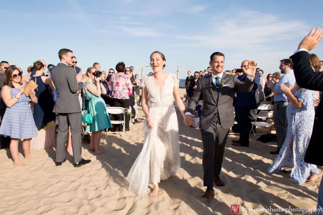 Bride and groom greet guests happily at end of Asbury Park beach wedding ceremony photographed by Kyo Morishima