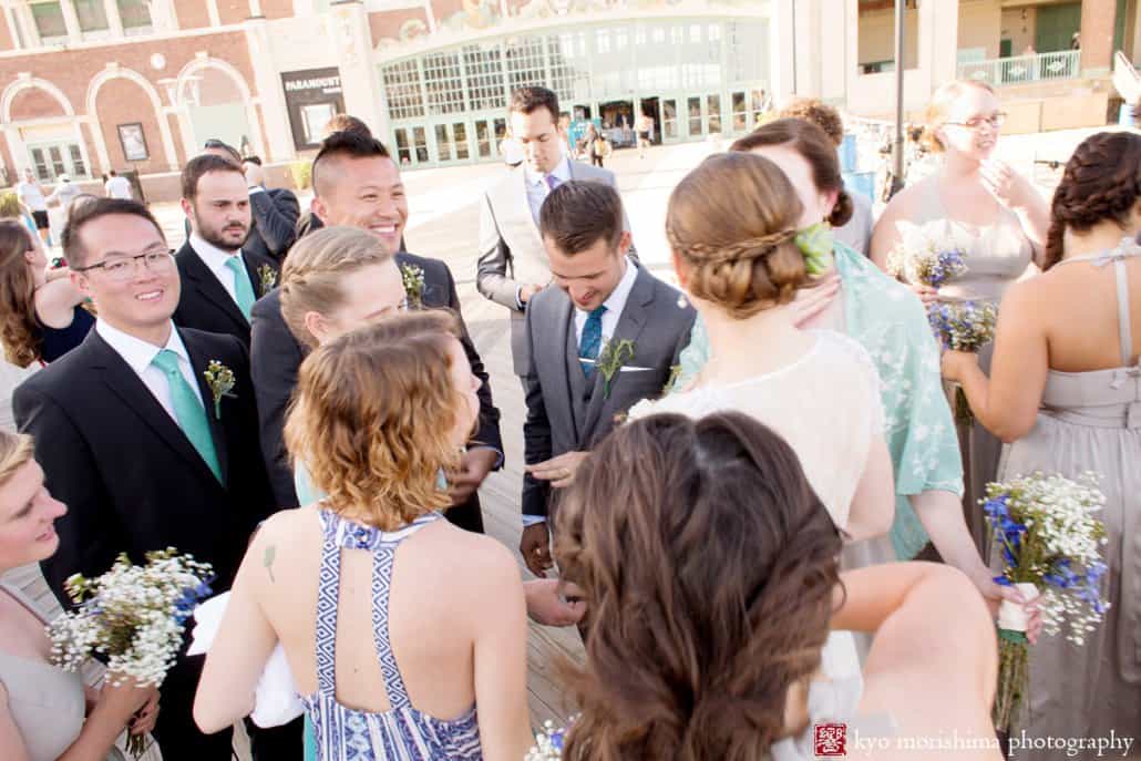 Groom shows his wedding ring to guests on Asbury Park boardwalk, photographed by Kyo Morishima