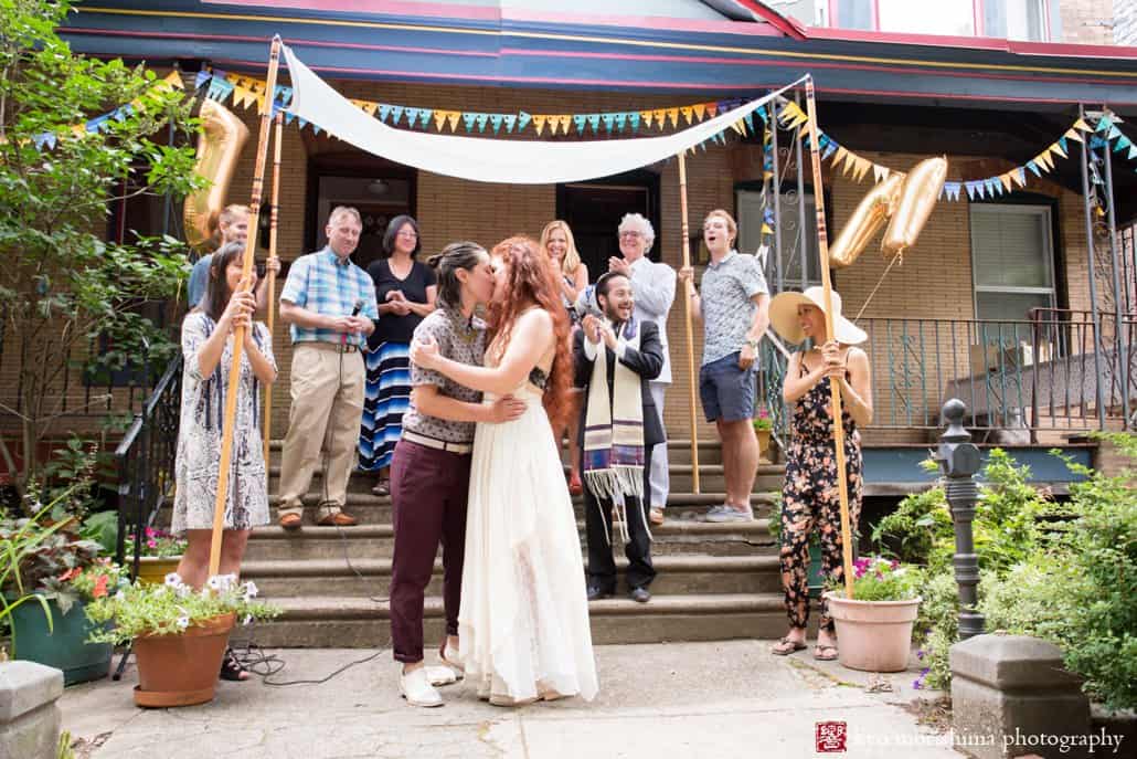 Brides kiss as West Philadelphia outdoor wedding concludes, photographed by Kyo Morishima
