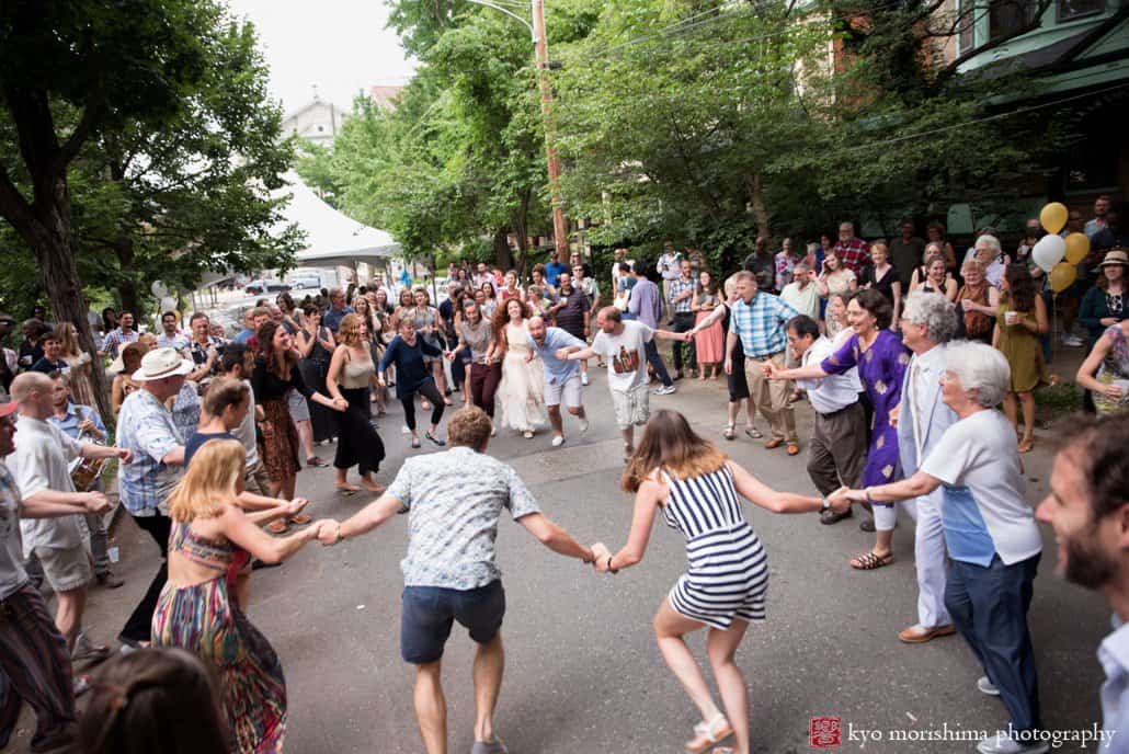Wedding guests dance in a circle at West Philly block party wedding with music by the West Philadelphia Orchestra, photographed by Kyo Morishima