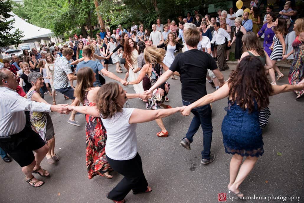 Wedding guests dance holding hands at West Philadelphia block party wedding photographed by Kyo Morishima