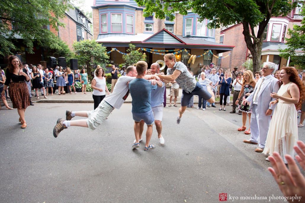 Guys spin in the air to music by the West Philadelphia Orchestra during block party wedding in July, photographed by Kyo Morishima