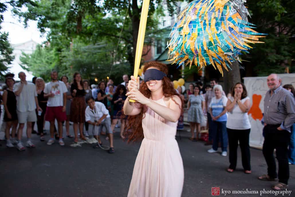 Bride attempts to hit the pinata at West Philadelphia block party wedding photographed by Kyo Morishima