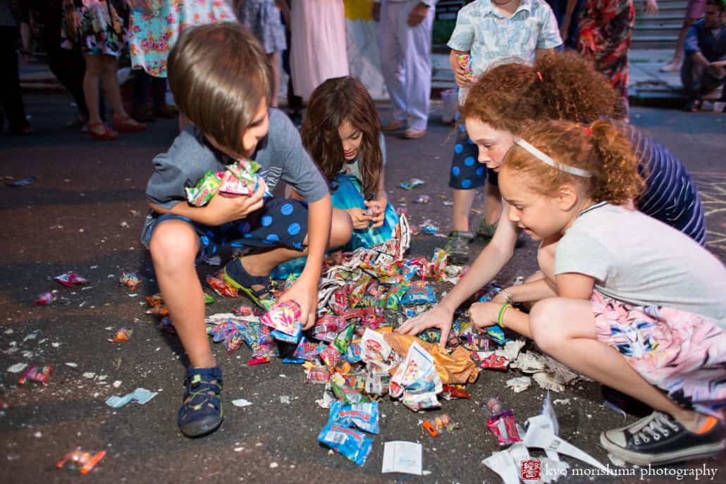 Kids crowd around candy that has come out of the pinata at block party wedding in West Philadelphia photographed by Kyo Morishima