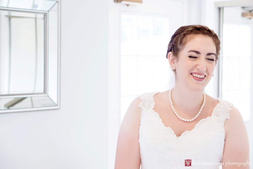 Bride laughs as she gets ready in Perona Farms bridal suite, photographed by Andover wedding photographer Kyo Morishima