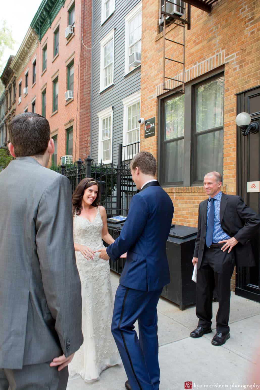 First look on Cobble Hill street; bride smiles at groom and they hold hands; photographed by Kyo Morishima