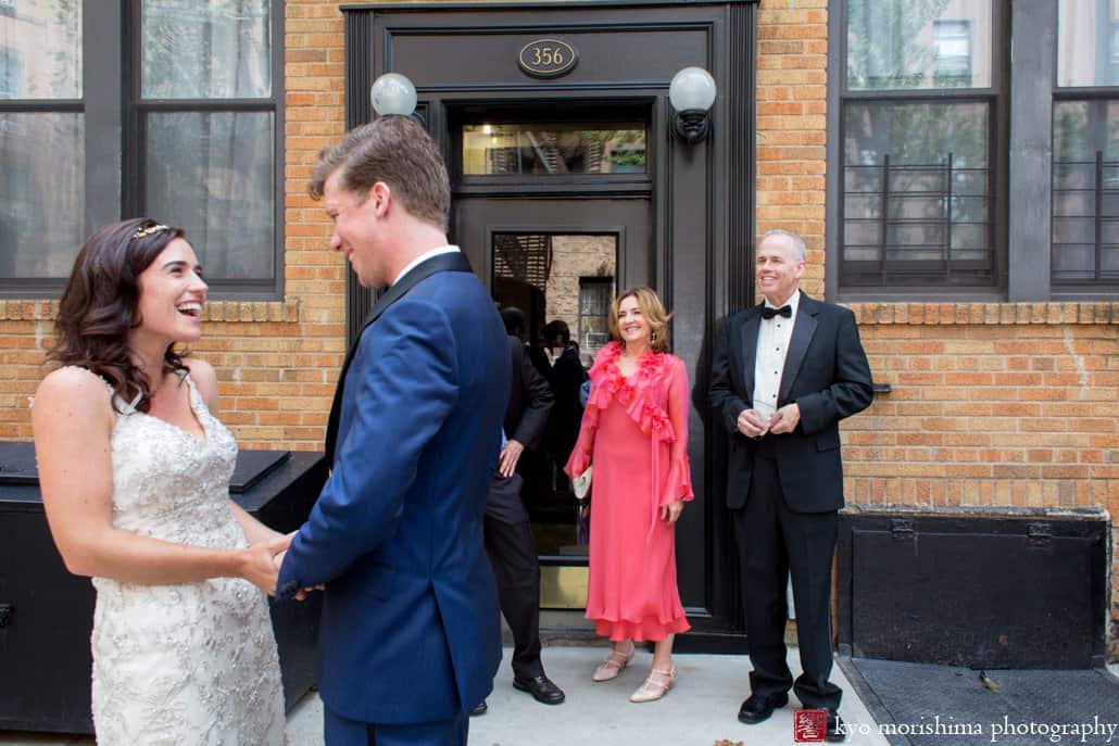 First look on Cobble Hill street; bride smiles at groom and they hold hands; photographed by Kyo Morishima