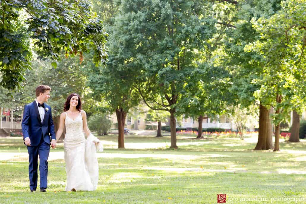 Bride and groom walk across the lawn before Governors Island wedding ceremony; bride wears Maggie Sottero wedding gown and groom wears Ted Baker suit, photographed by Kyo Morishima